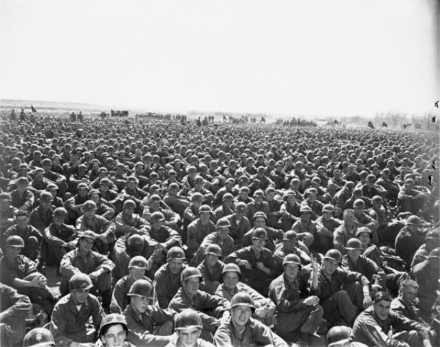 Black and white photo of a crows soldiers sitting down on the ground.