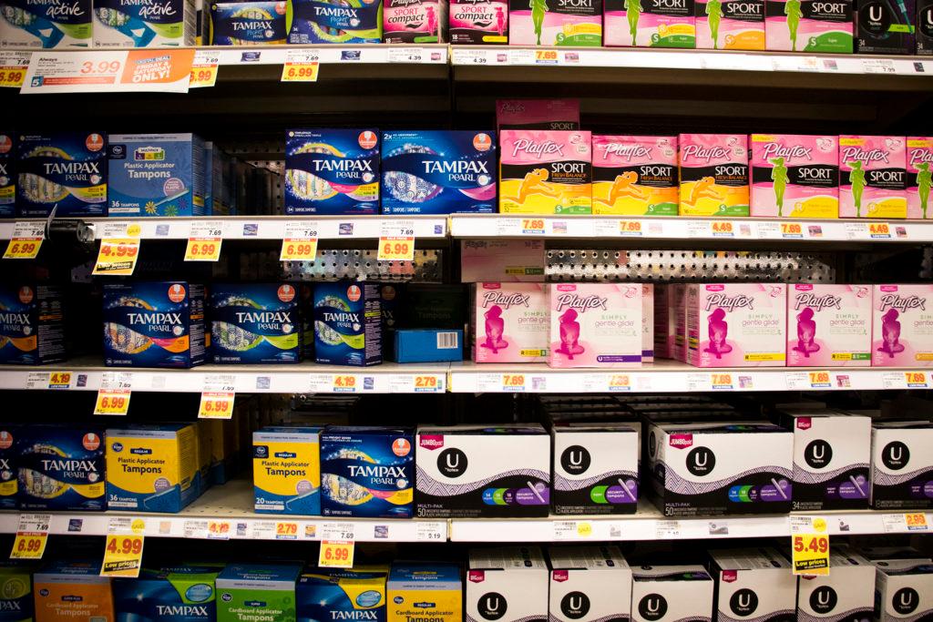 Several brands of tampons on shelves in a grocery store