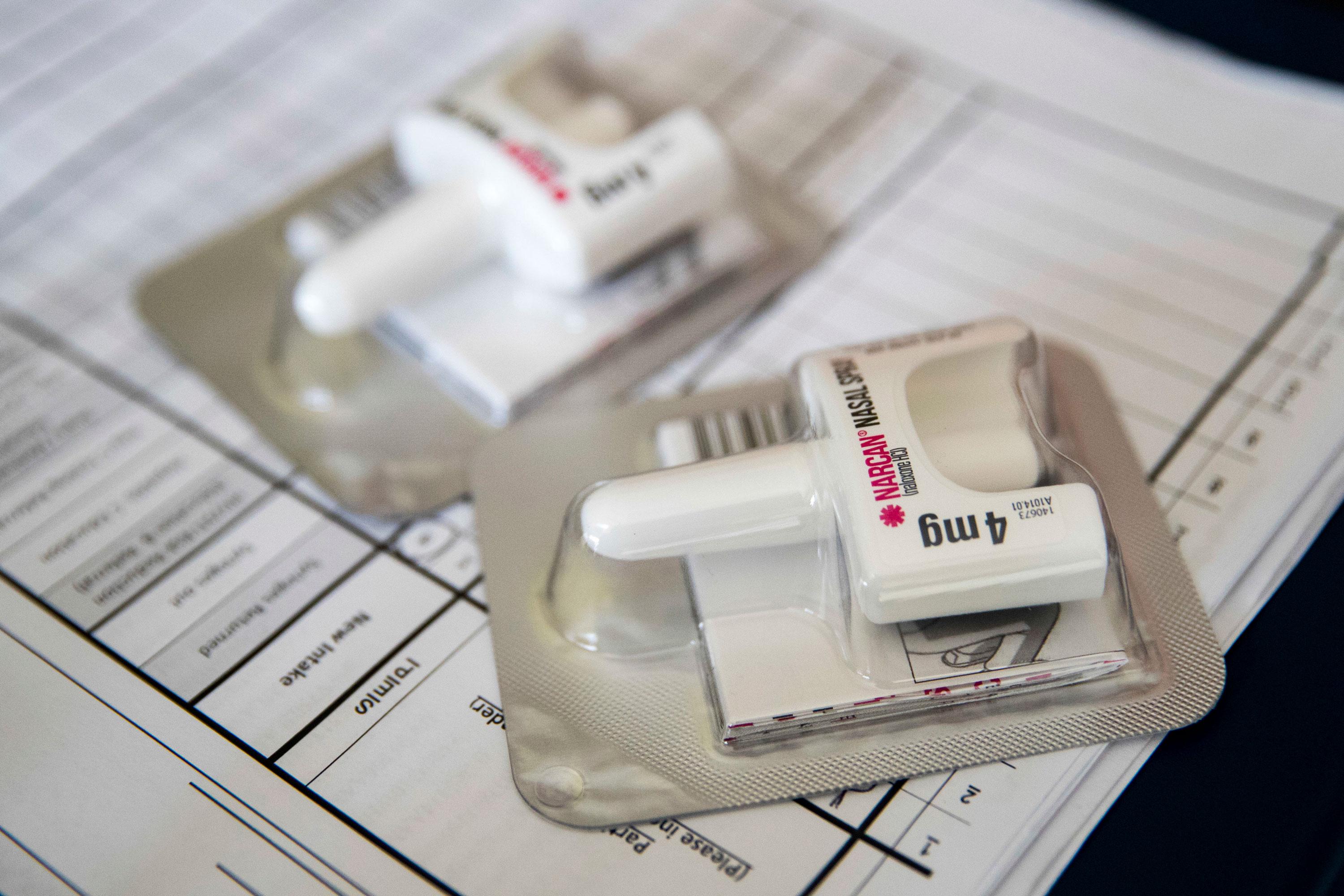 Two Narcan nasal devices sit on top of paperwork
