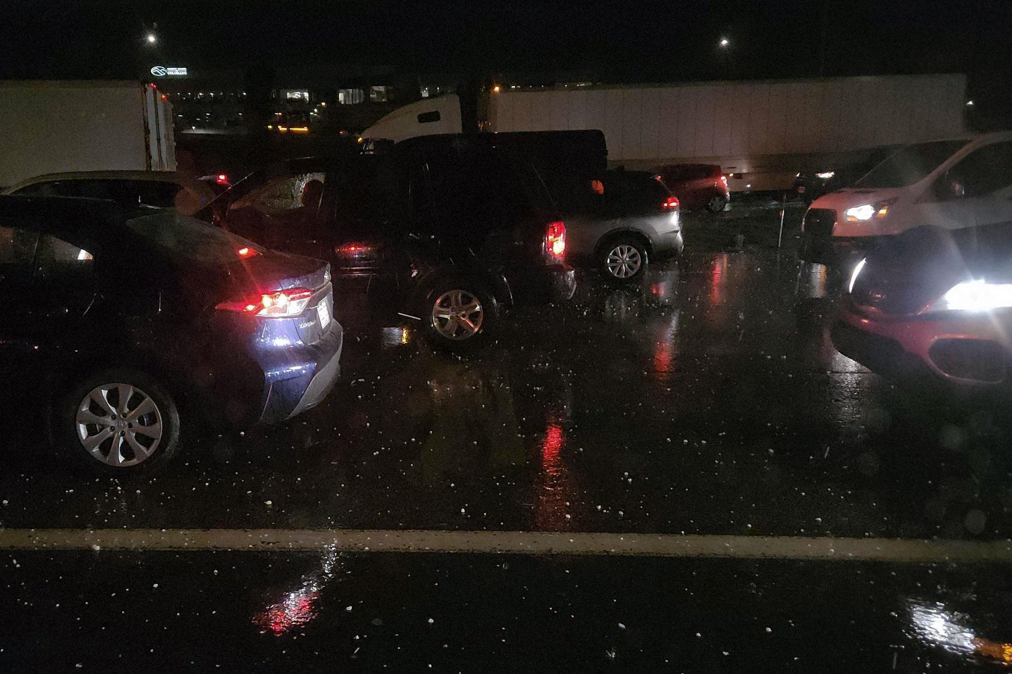 Rows of car and trucks stuck in traffic during a hailstorm on.