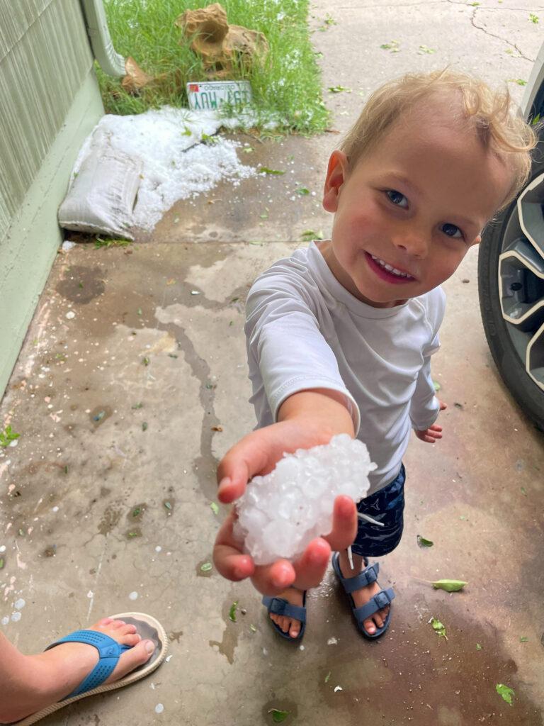 Three-year-old Linden Scott holds up hail collected outside his Grand Junction home after a rare thunderstorm rolled through on June 20, 2024.