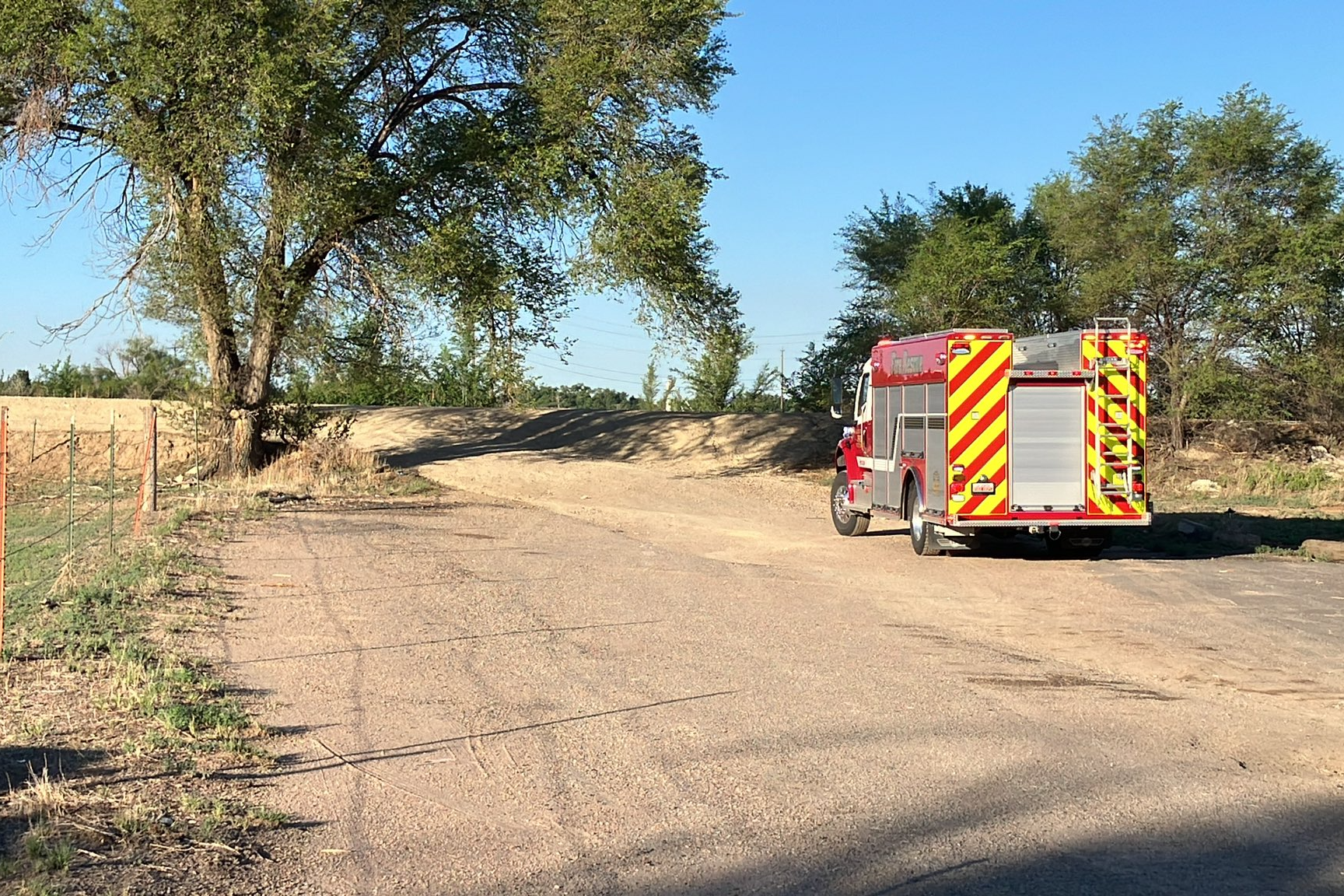 A firetruck with the La Junta Fire Department parked to the side of a dirt road in Otero County near the Arkansas River for a water rescue.