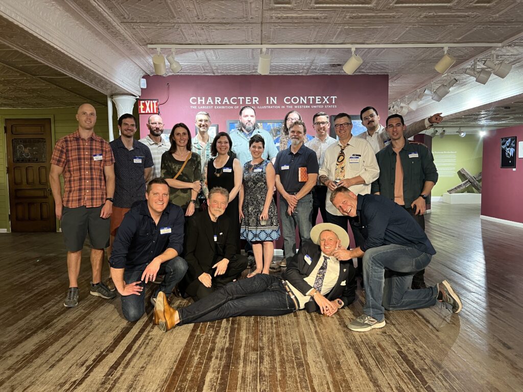 Museum board president Cody Kuehl (front row, left) and curator Elliot Lang (front row, second from right) pose with artists at the opening reception for 'Character in Context' at the A.R. Mitchell Museum of Western Art