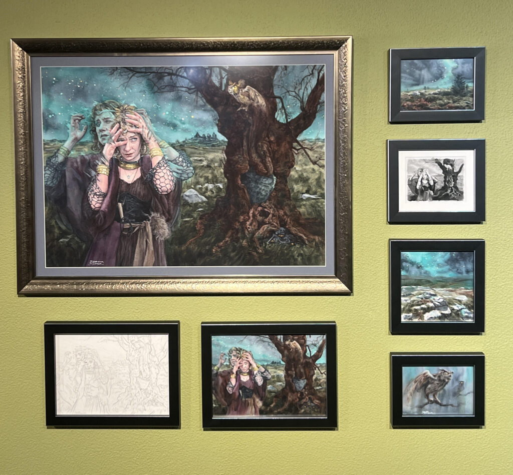 A selection of works on display as part of the 'Character in Context' exhibit, featuring one large image of a witchy-looking woman near a gnarled tree.