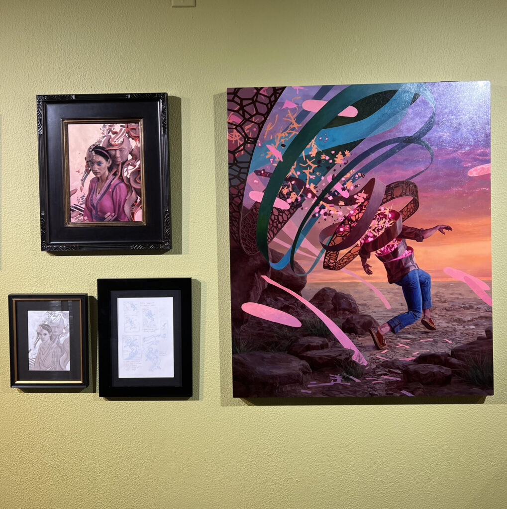 A selection of works, including one large, surreal image of a person walking through the desert and unraveling into multi-colored ribbon and stardust.