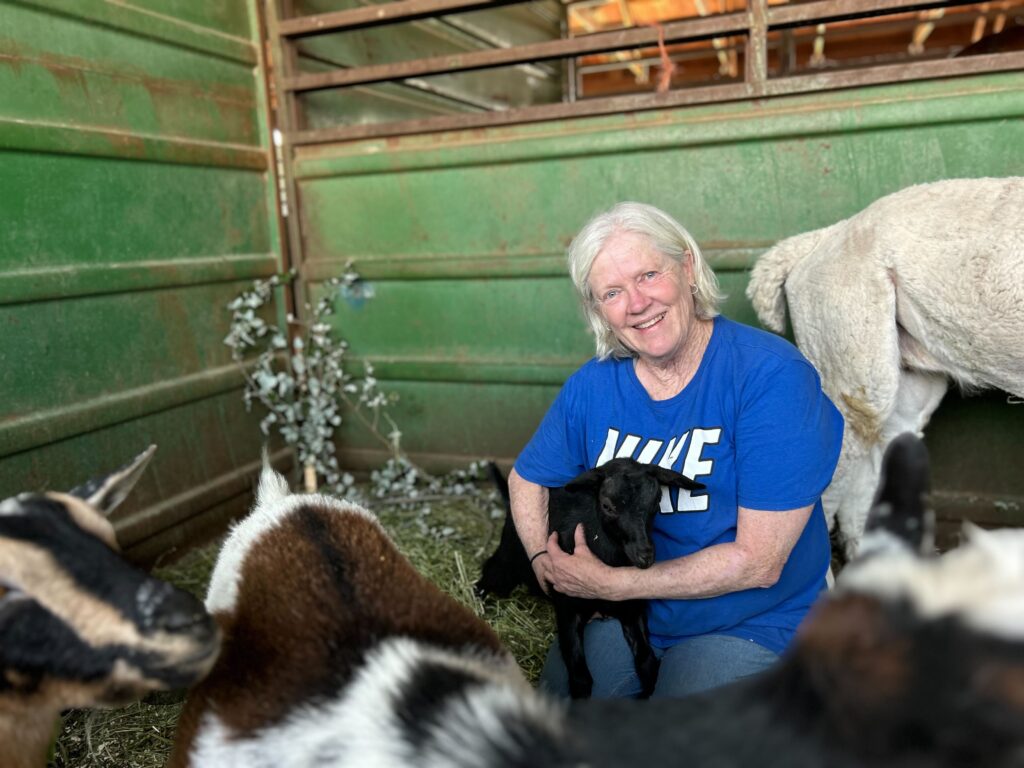 A woman holds a goat that she brought with her when she evacuated a wildfire.