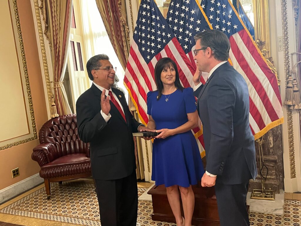 a swearing-in ceremony between two men while a woman holds a bible being used