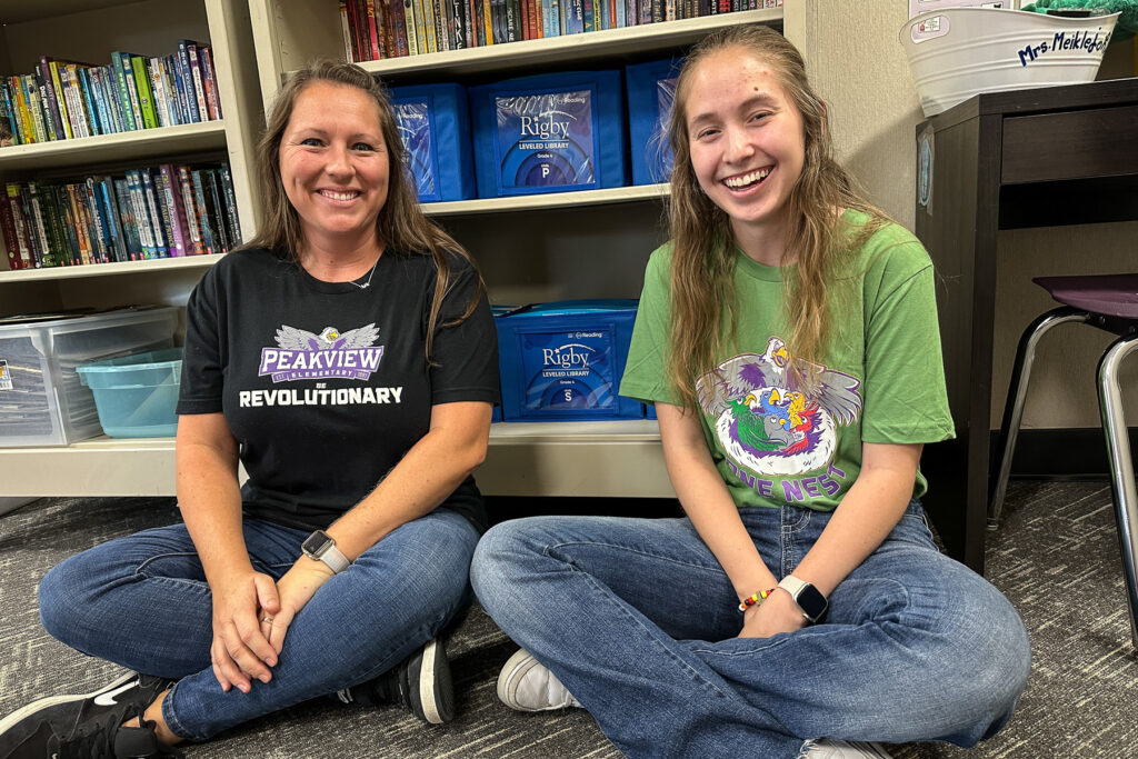 A teacher sits with her teacher apprentice.