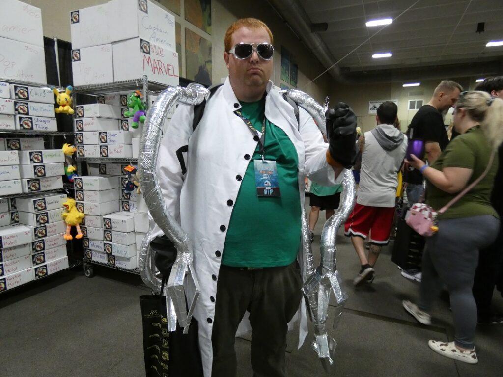 A man poses in a lab coat with foil tentacles coming from his back