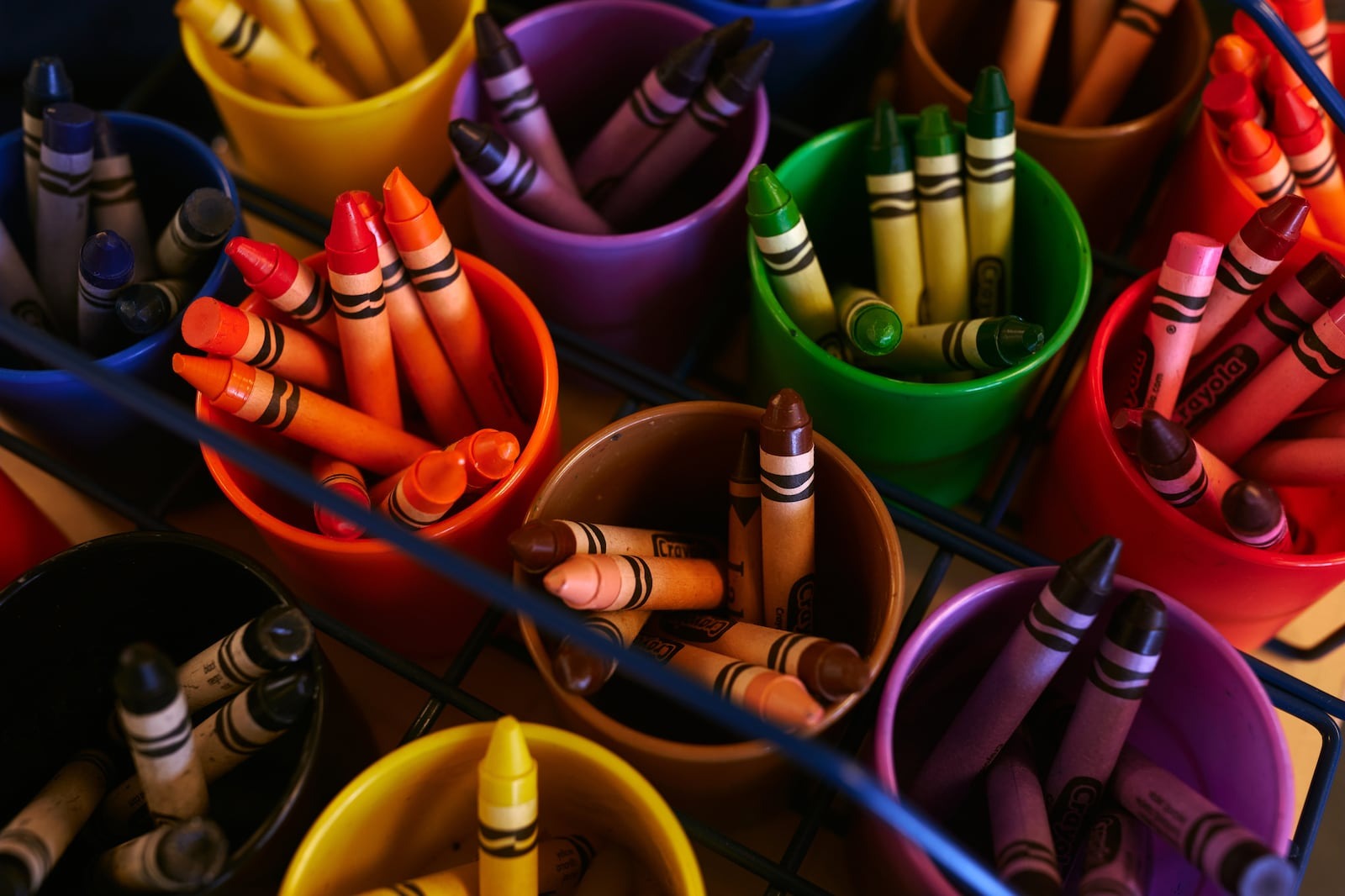 Cups filled with crayons.