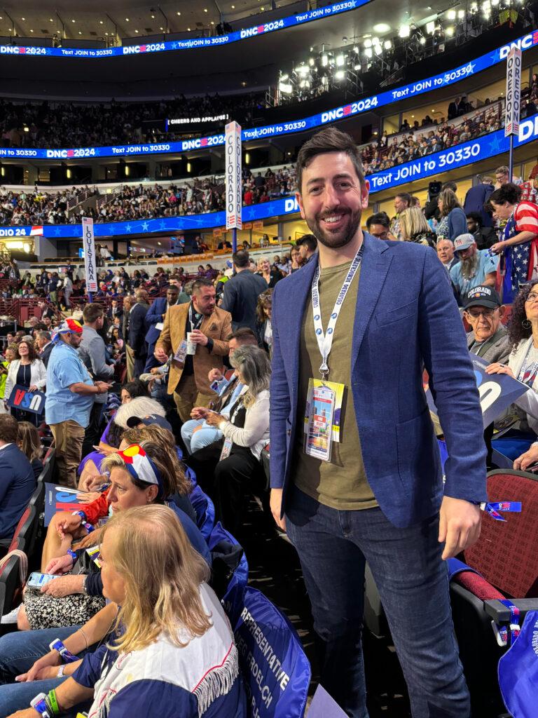 Erik Clarke of Denver is seen at the Democratic National Convention in Chicago with the crowd of delegates behind him. in the seating area.