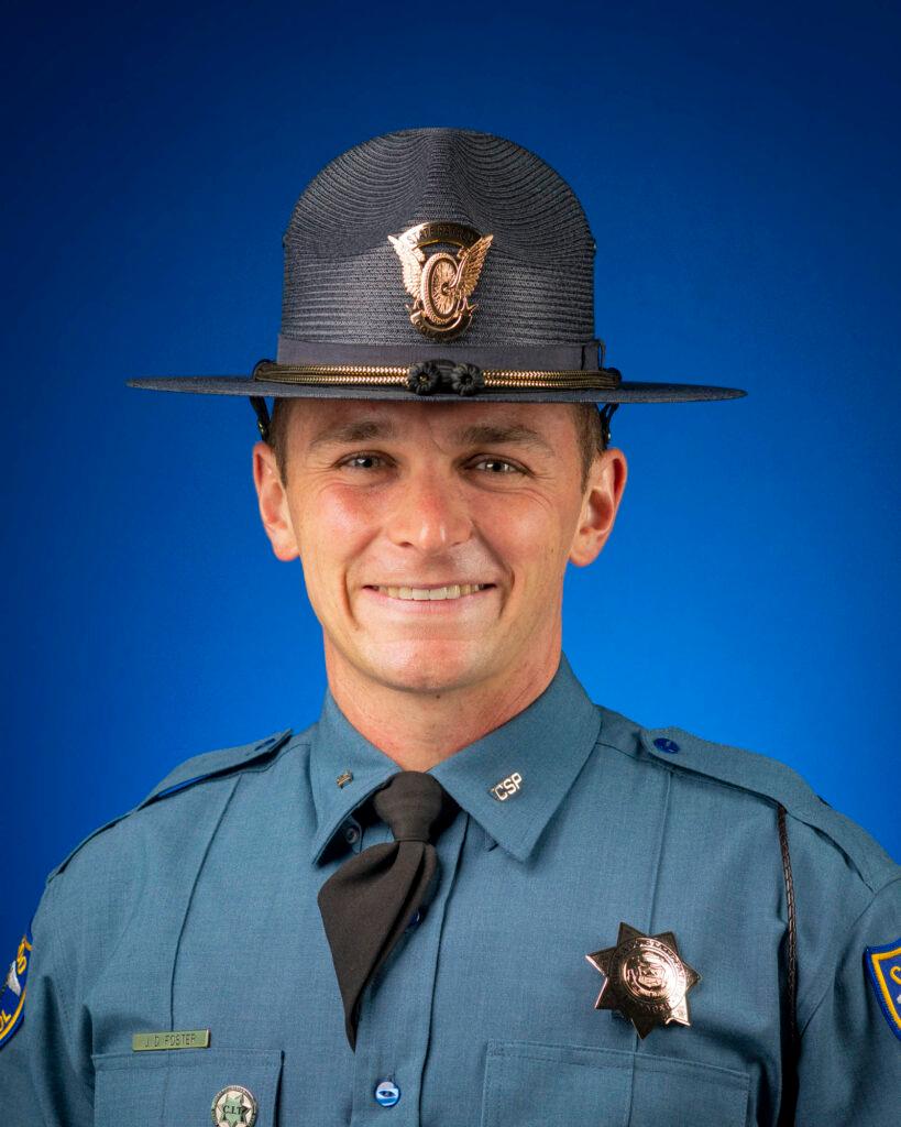 Man in police uniform smiling directly at camera