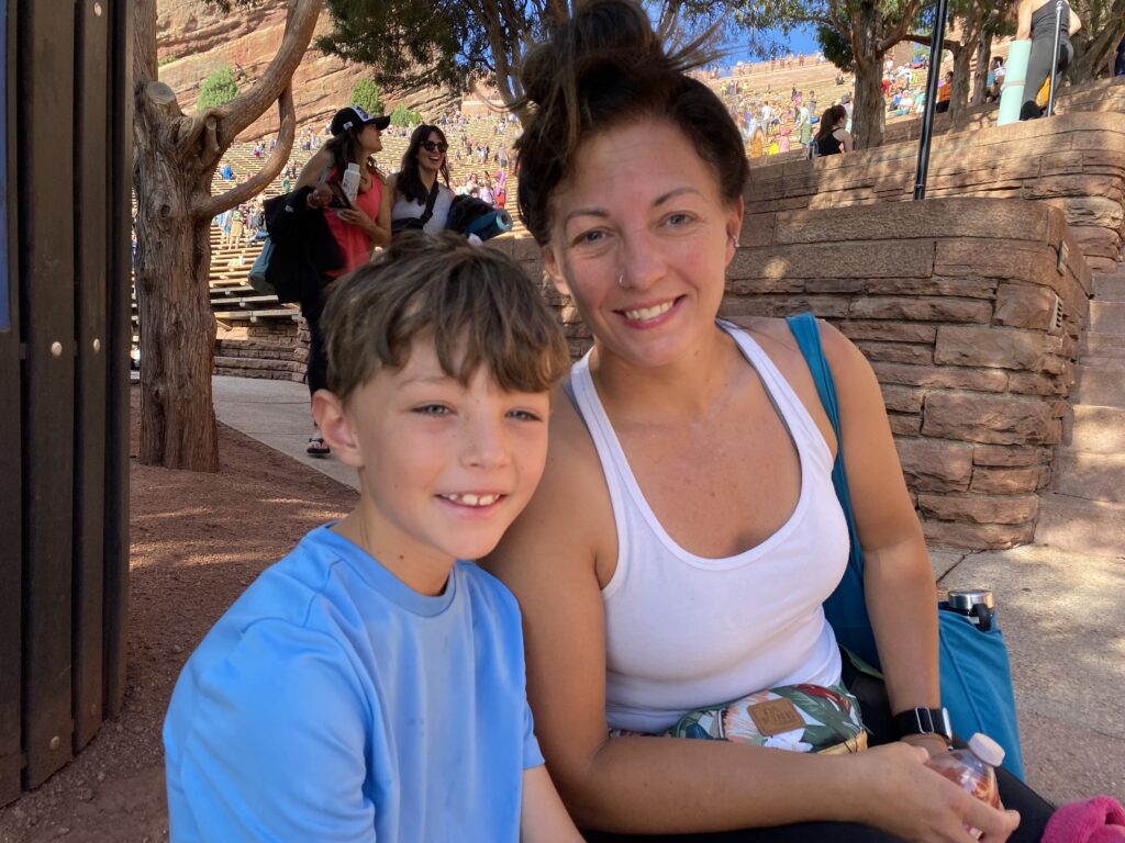 A mom and son pose at Red Rocks before a yoga session