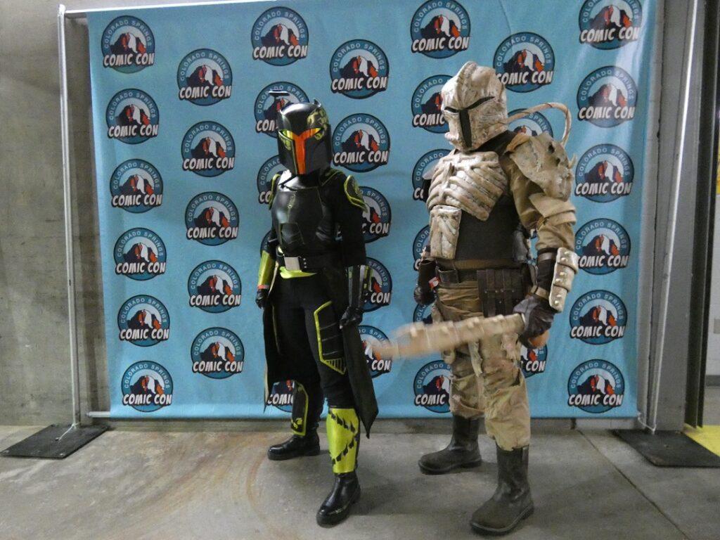 Two people in Star Wars Mandalorian inspired costumes.