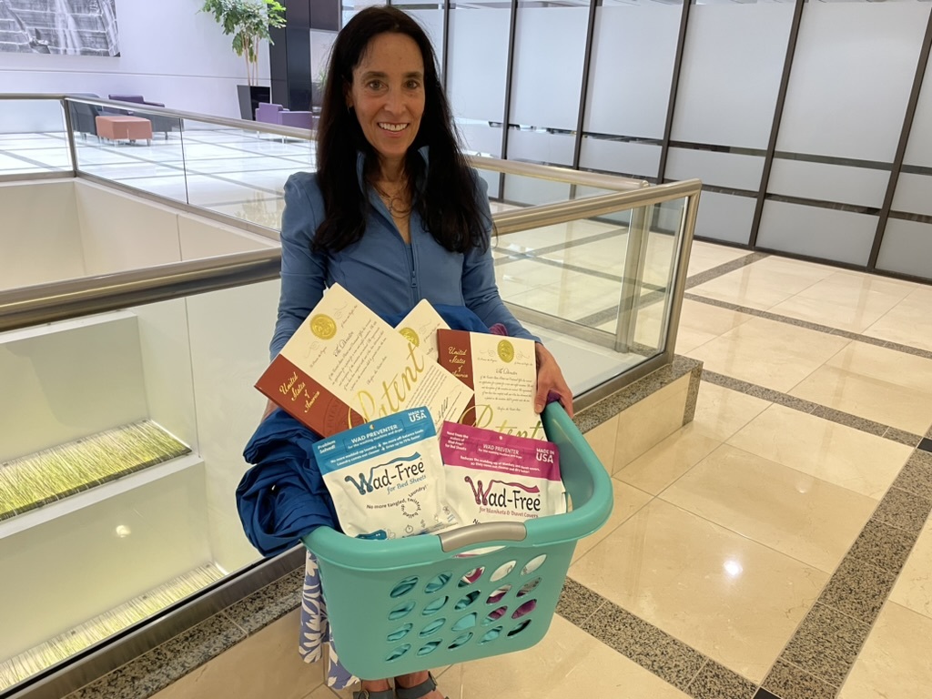 Cyndi Bray of Denver, holds a basket of her invention, Wad-Free, and its patents.