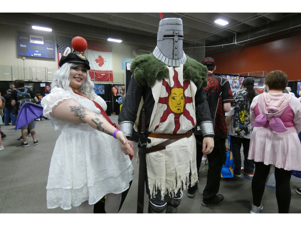 A woman in a white dress and a man in a knight costume.