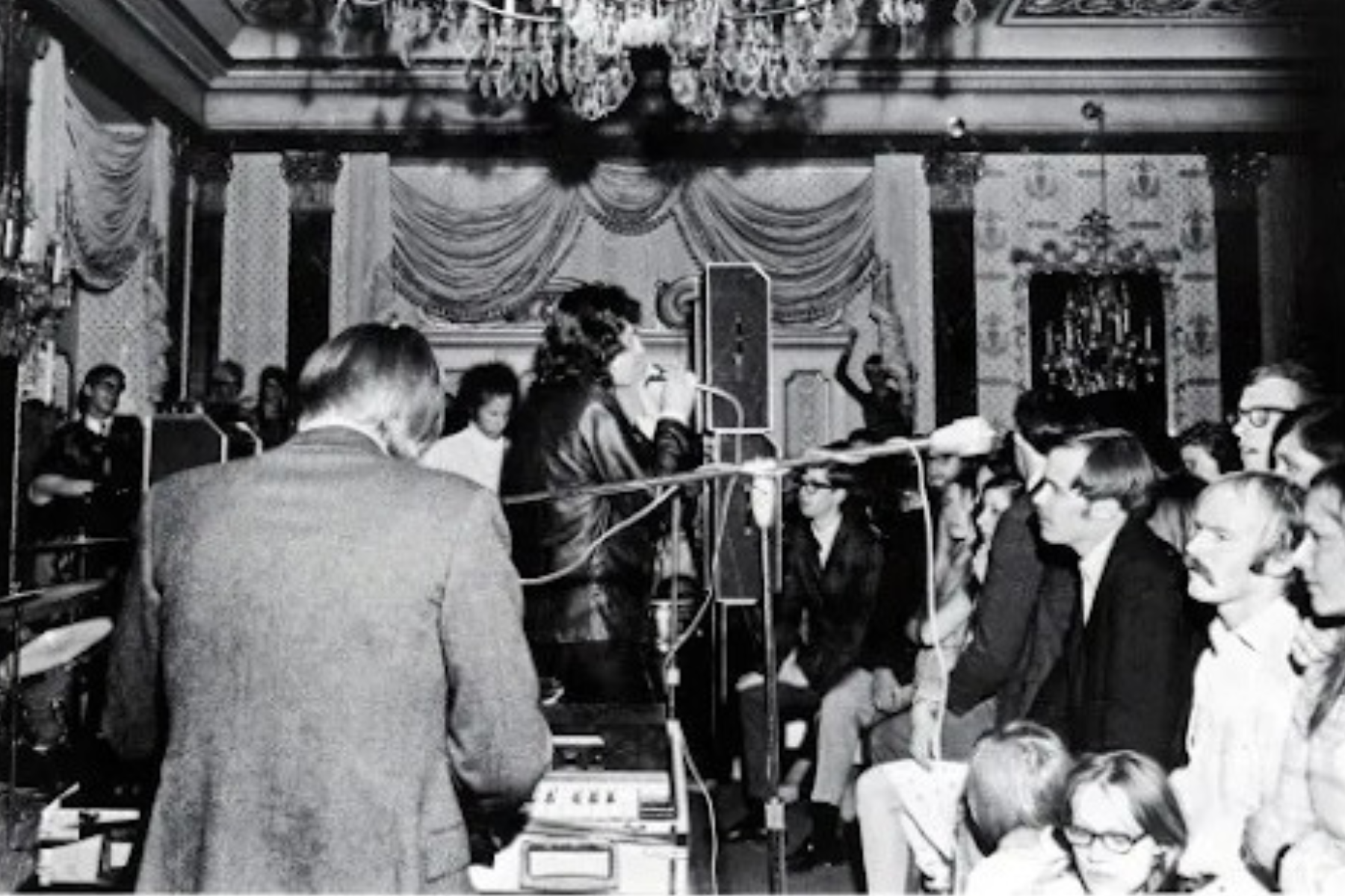 Jim Morrison of the Doors sings into a microphone onstage at the homecoming for Colorado College in 1967.