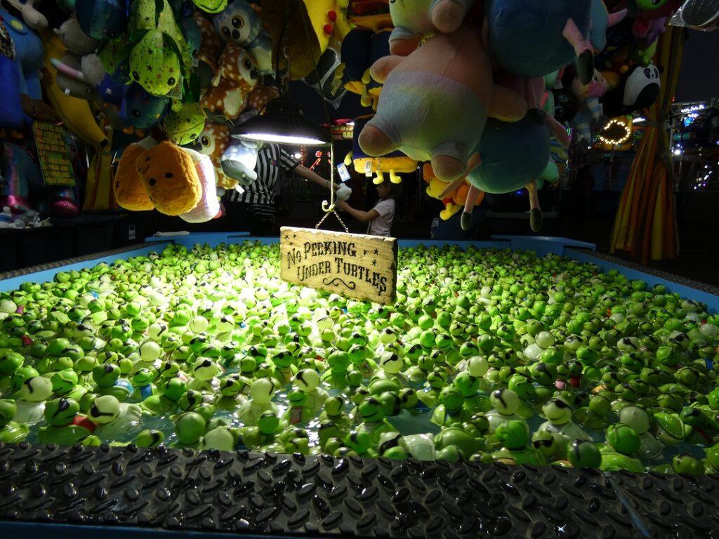 a tub filled with green floating toy turtles