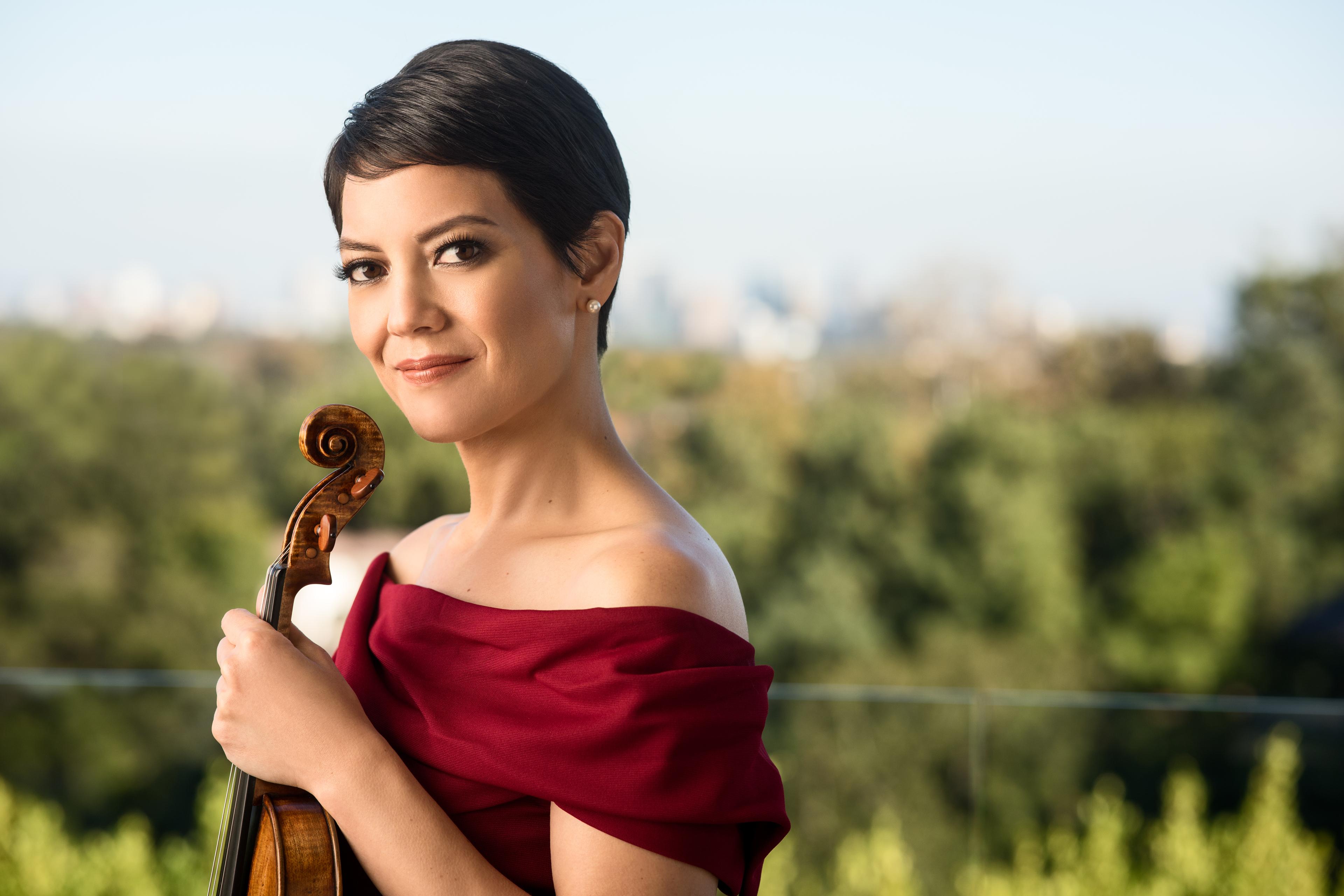 Profile shot of a woman holding her violin.