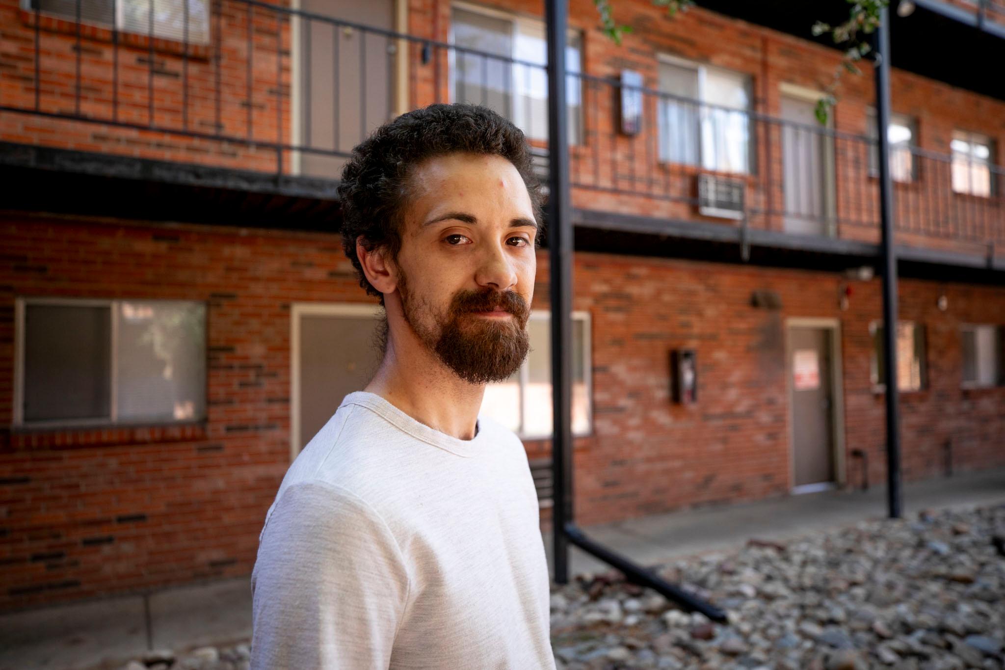 Chris Tatum stands in the courtyard of the apartment complex