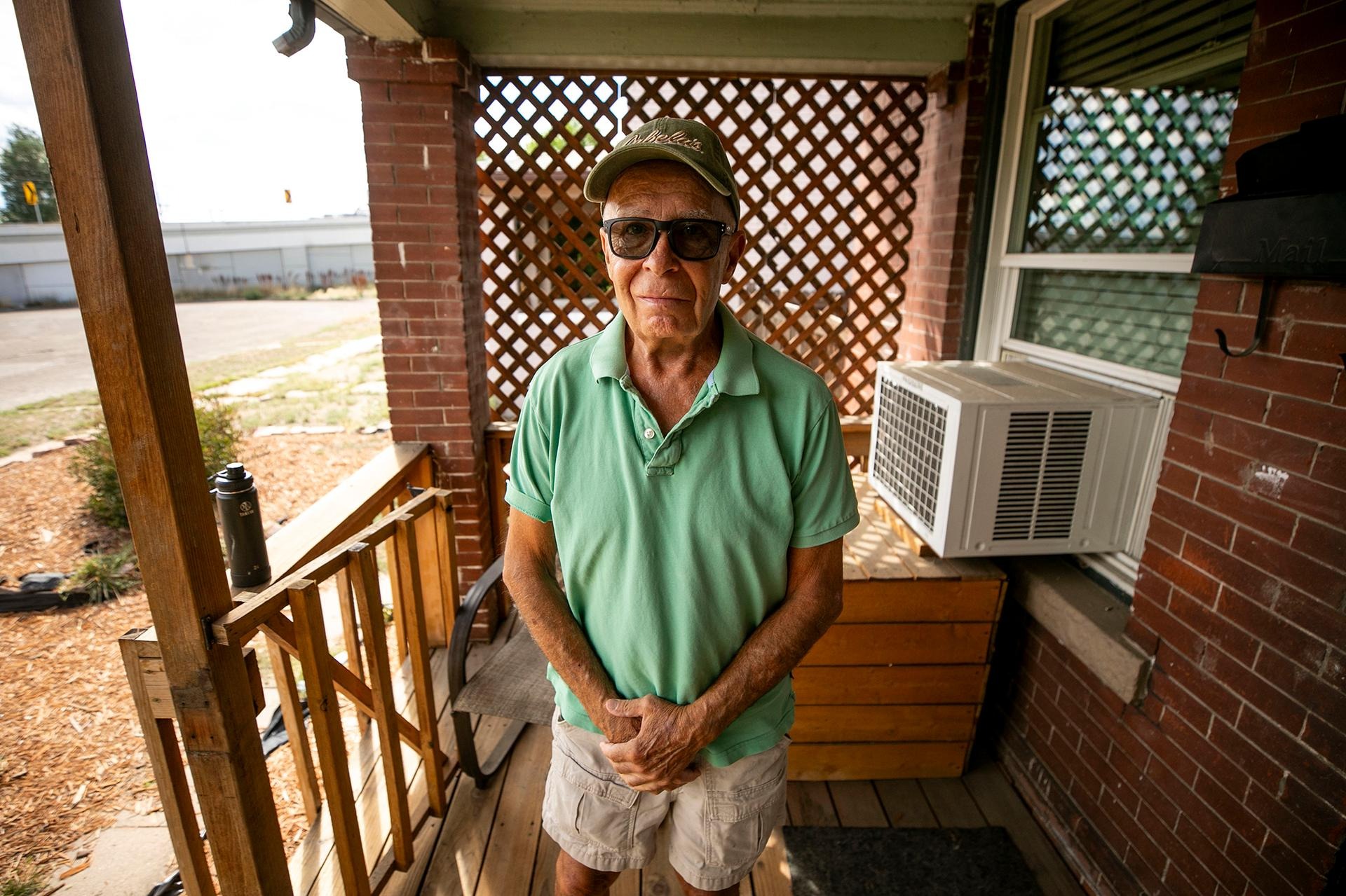 Robert McDermott stands on his porch, in a cluster of homes by I-25’s on- and off-ramps at Broadway that were, until recently, slated for demolition. Sept. 17, 2024.