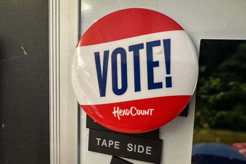 A button hangs on a classroom wall.