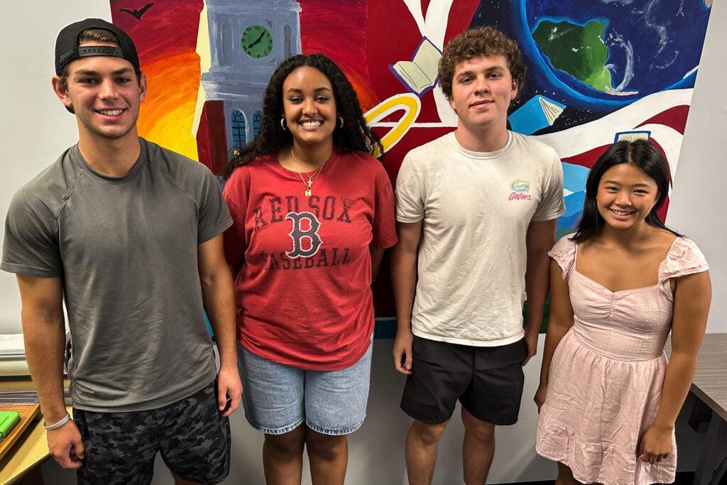 Four students stand for a photo in school.