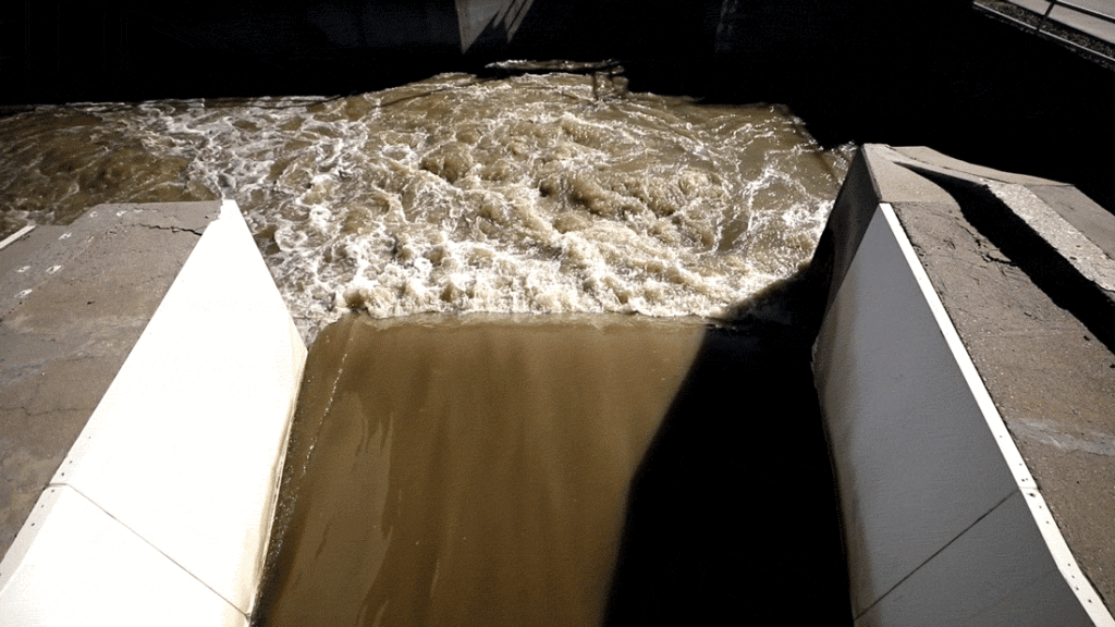 A river of raw sewage flows into a treatment facility