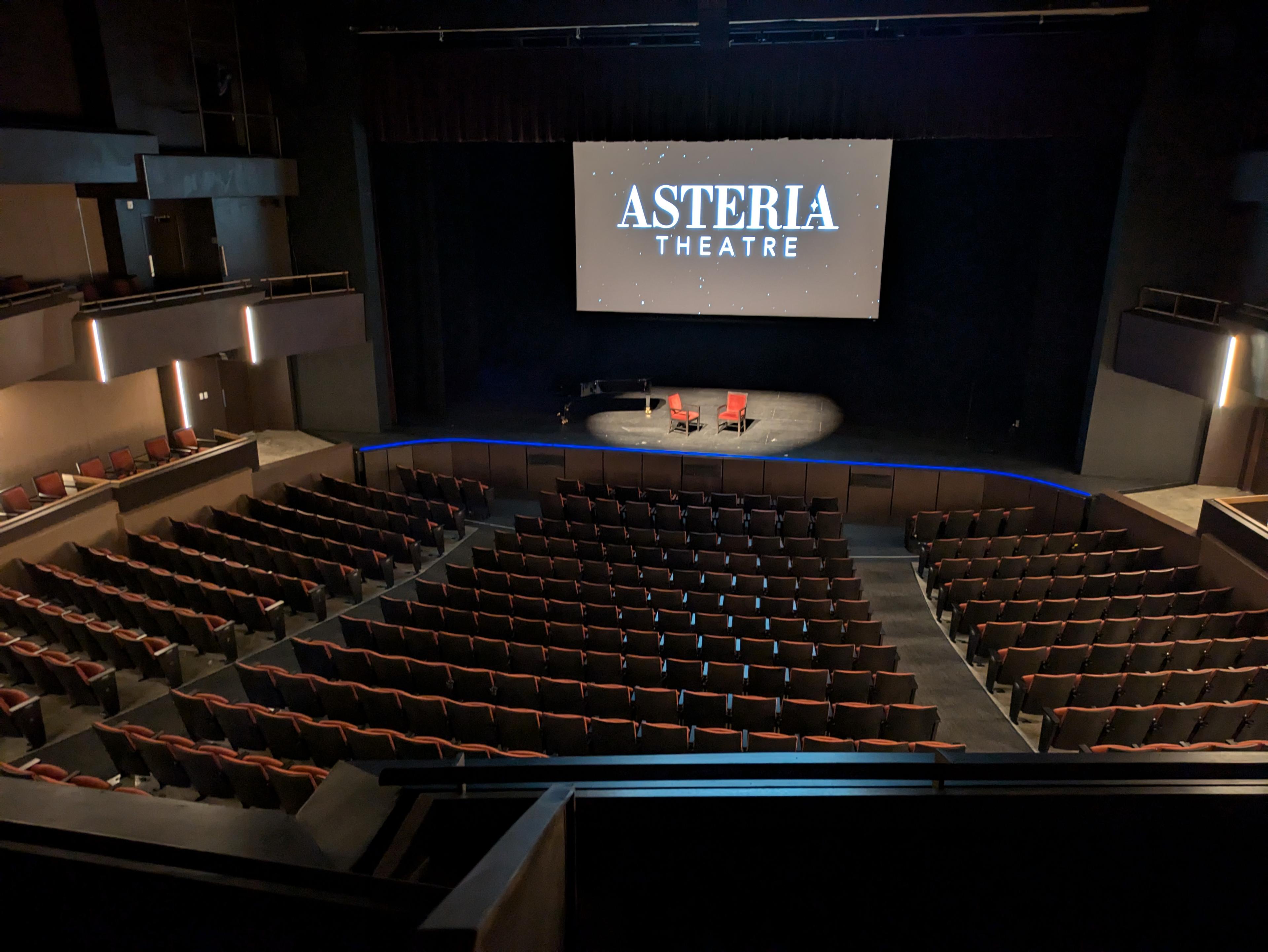 An empty theatre viewed from the middle balcony seating.