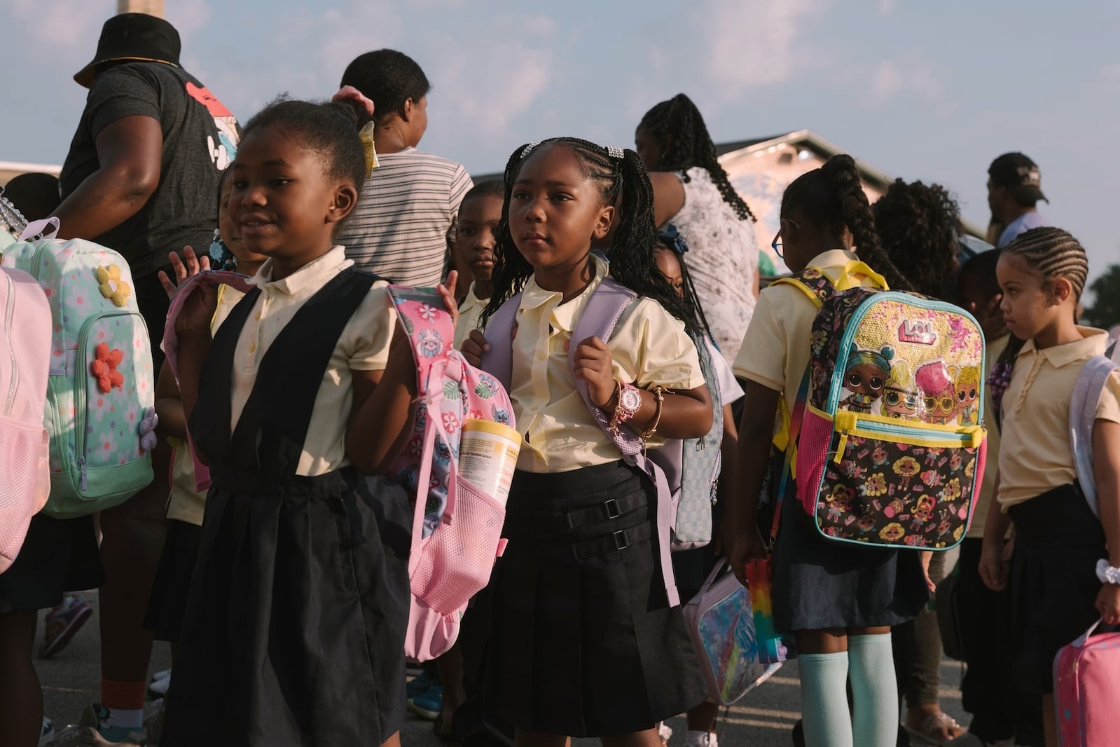 Group of students in uniforms wearing backpacks