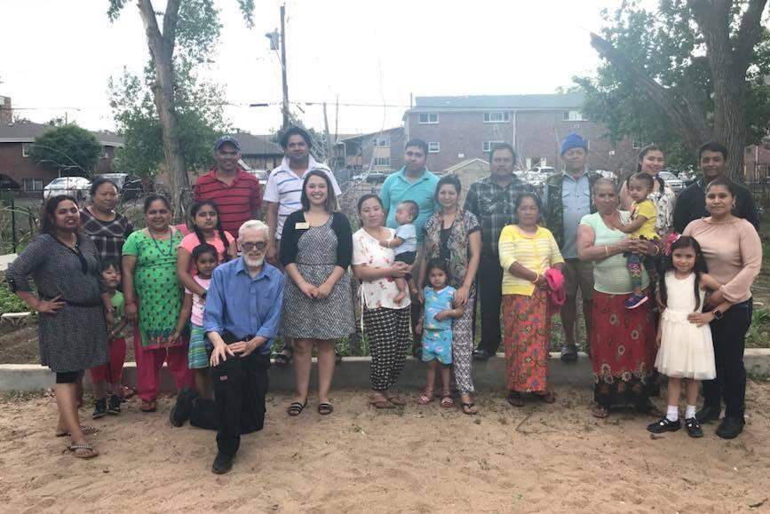 group of people standing together outside community garden in Denver