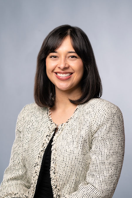 image of woman in off-white blazer and black top smiling in profile in professional photo