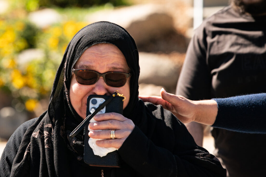 Khadija Alhidid, mother of Ahmad Alissa holds her phone to her face as she walks away, tearful, from speaking with reporters after verdicts were read.