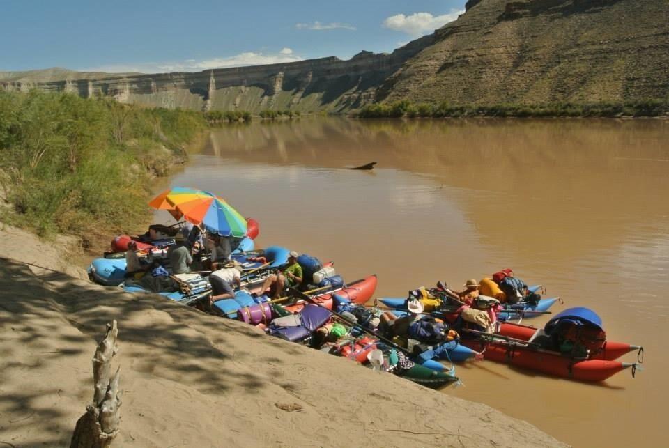 Women in their rafts getting ready to push off from the bank of the Colorado River.