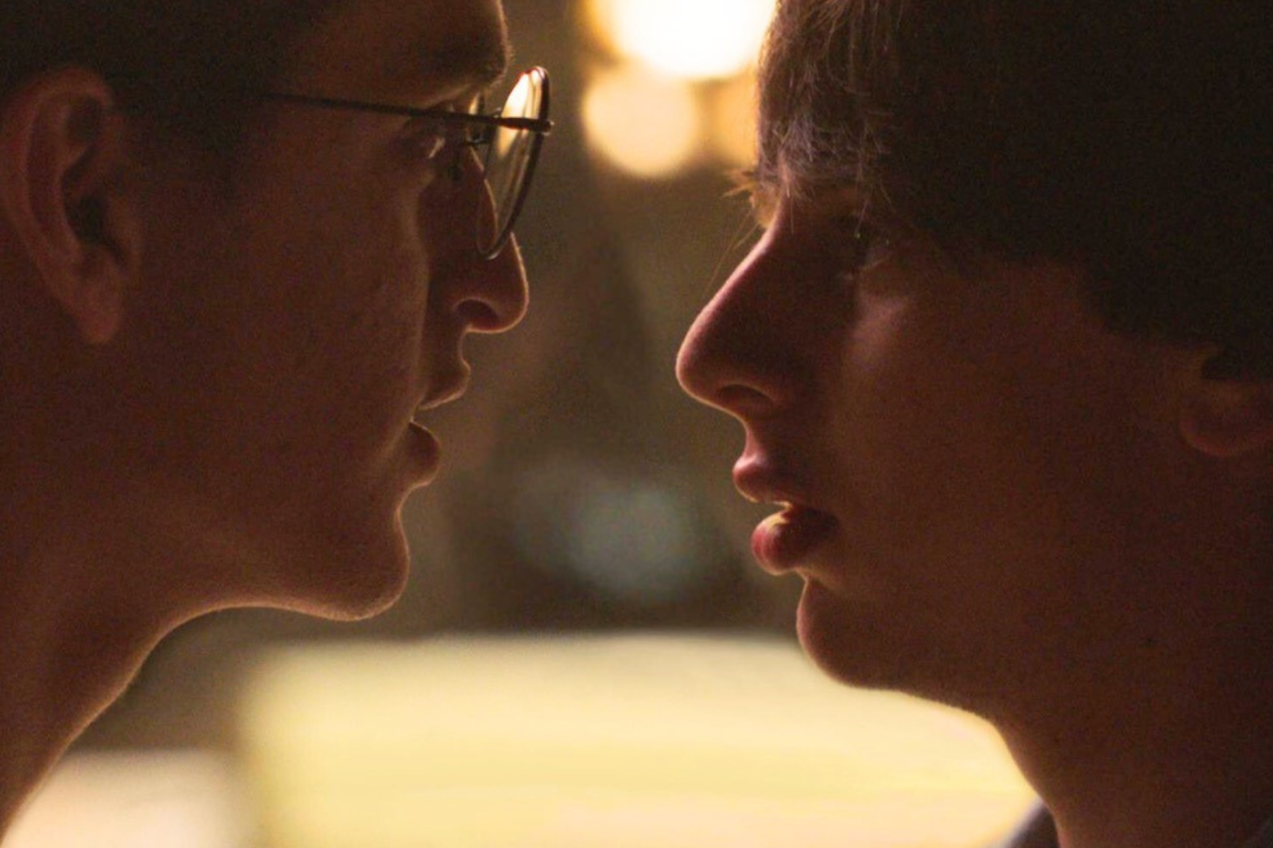 two young men are looking at each other face to face