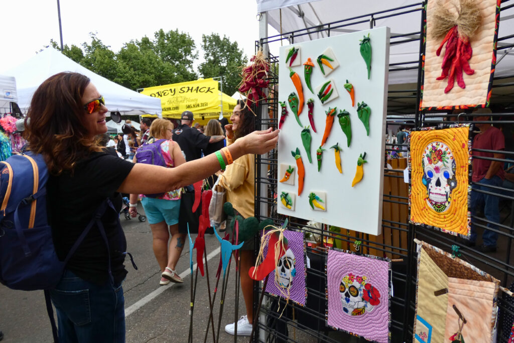 A woman looks at arts and crafts outdoors