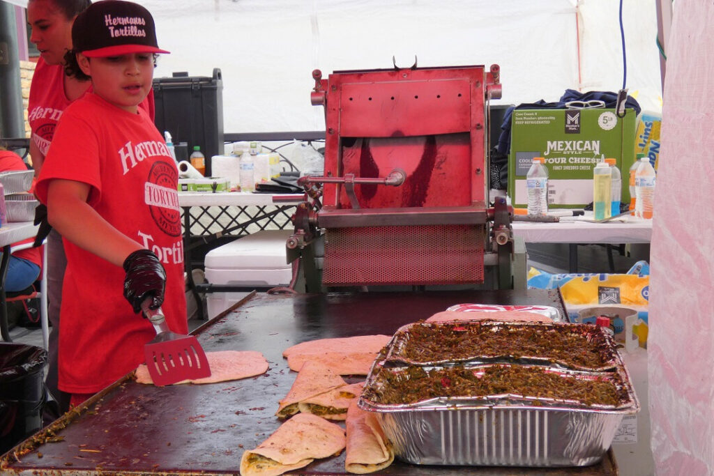 A young boy manages the cooking of quesadillas