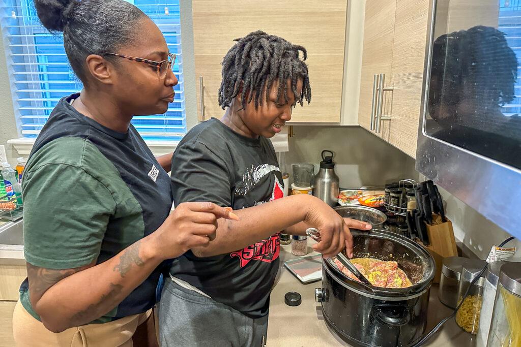 A boy cooks with his mom.