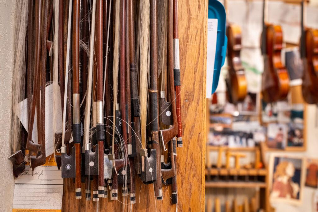 Violin bows hang in the workshop