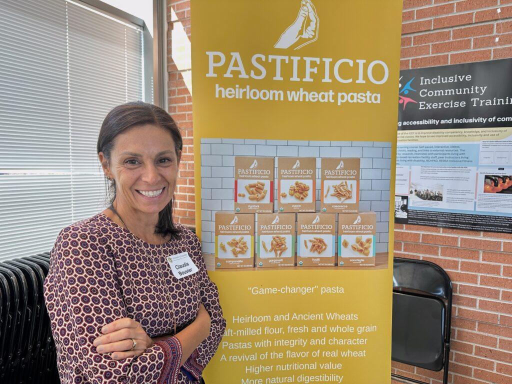 A woman stands next to a sign.