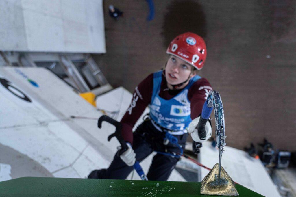 young woman with red hard hat and climbing gear