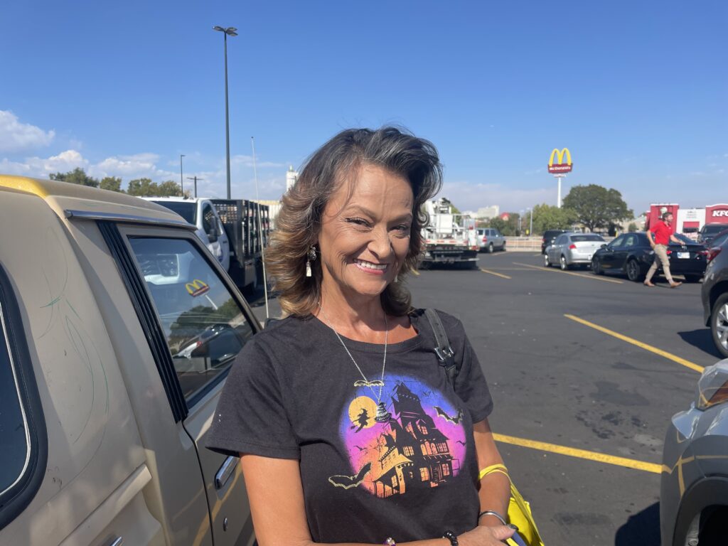 A smiling woman in a parking lot in Commerce City