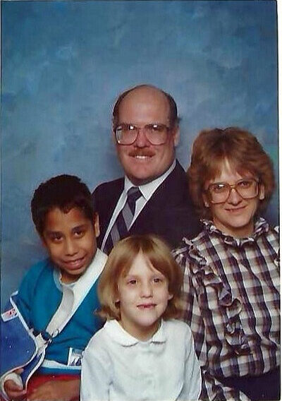 A man, woman, young girl and young boy pose for a photo