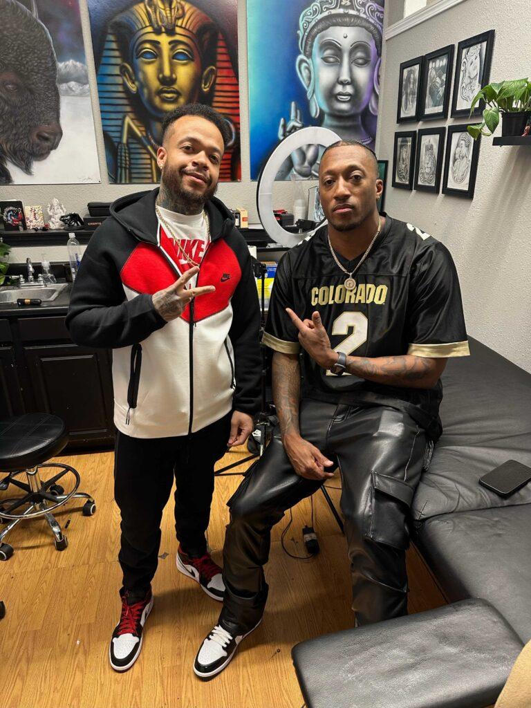 Tattoo artist Carlos Stokes poses with Christian rapper Lecrae Moore's in Aurora.