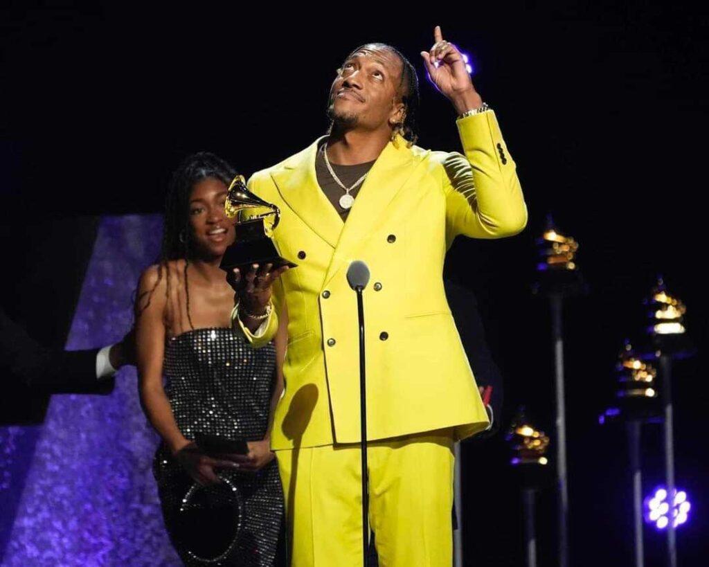 Christian rapper Lecrae accepts a Grammy at this year's awards ceremony. His daughter stands next to him on stage.