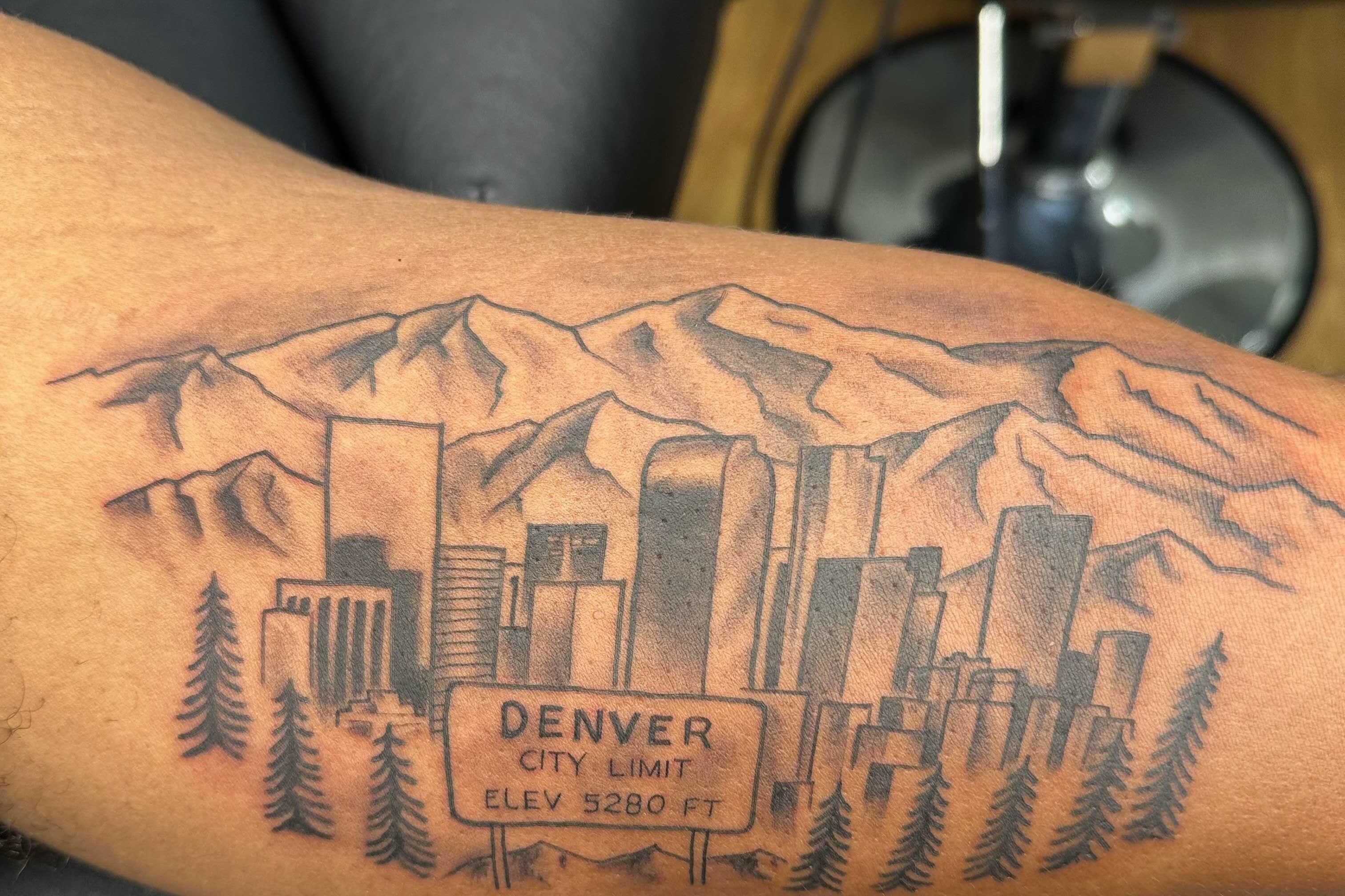 Photo shows a tattoo of the city of Denver skyline on the arm of Christian rapper Lecrae Moore.