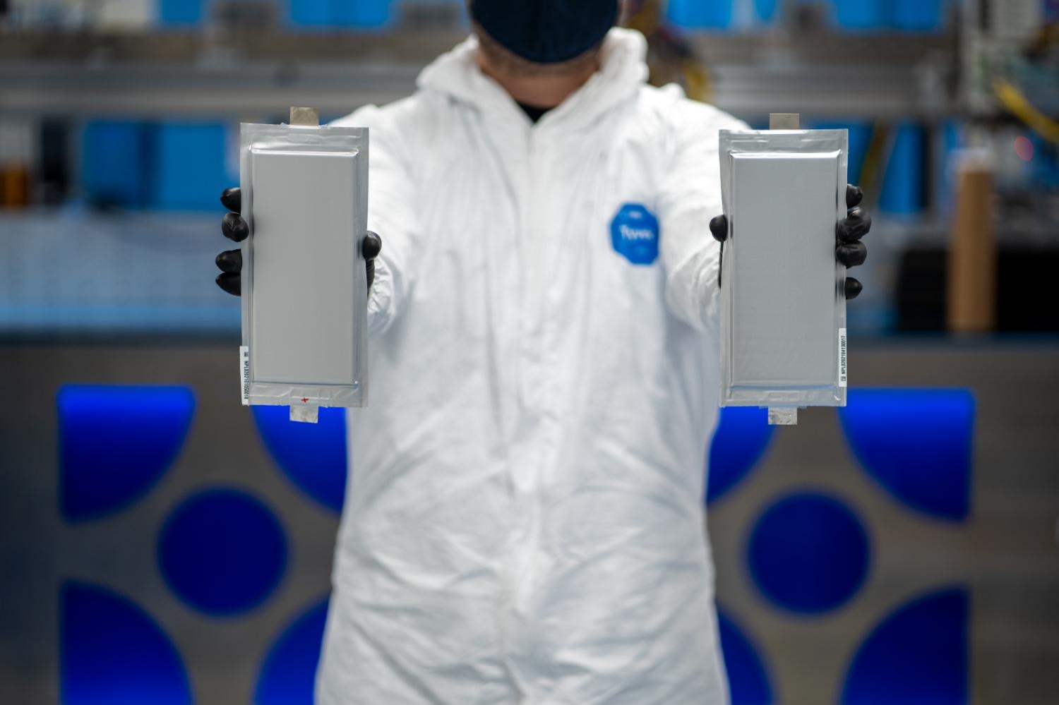 A person holds two battery cells.