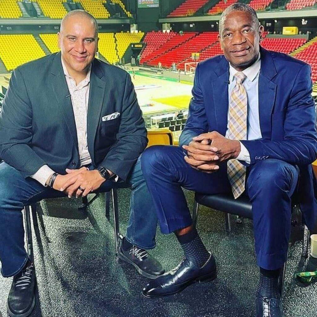 In the photo, sports journalist Marc Spears sits with basketball legend and former Denver Nugget player Dikembe Mutombo.