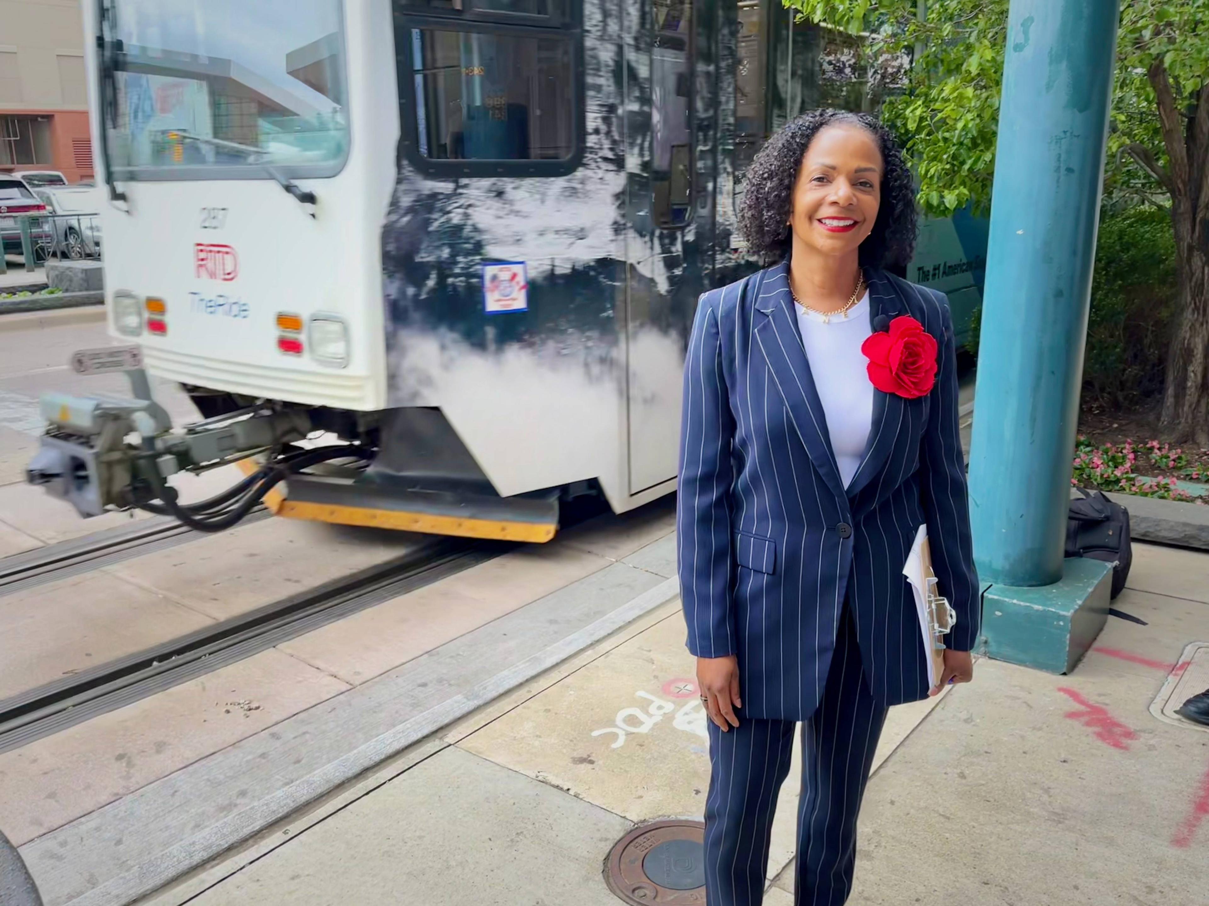 RTD General Manager and CEO Debra Johnson stands next to a recently repaired section of light rail track as a train passes by in downtown Denver.