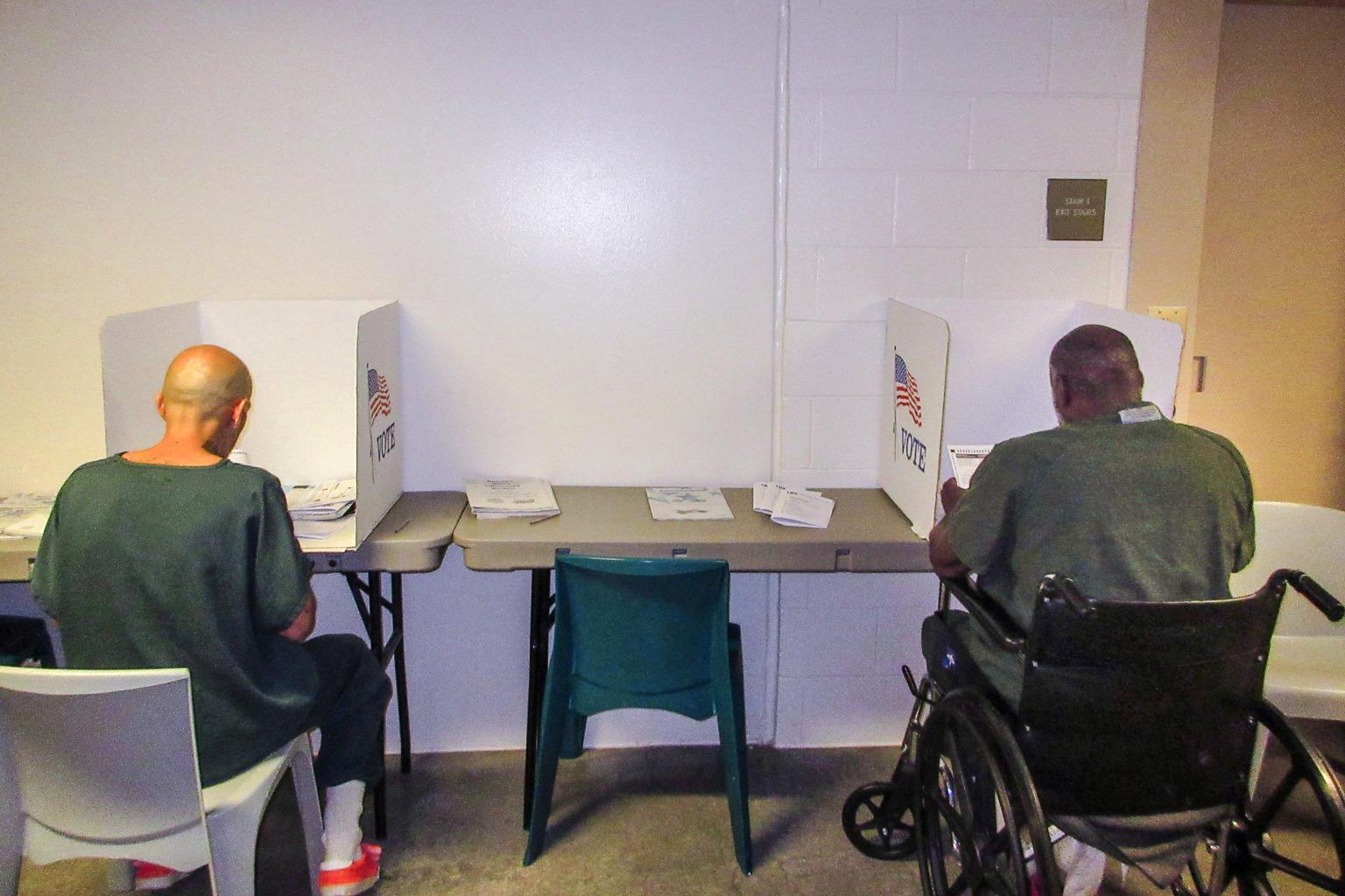 Raul Vidaurri (left) filling out his ballot at the Denver Detention Center,